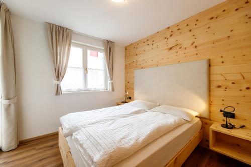 a bedroom with a white bed and a window at Residence Montebel in Tesero