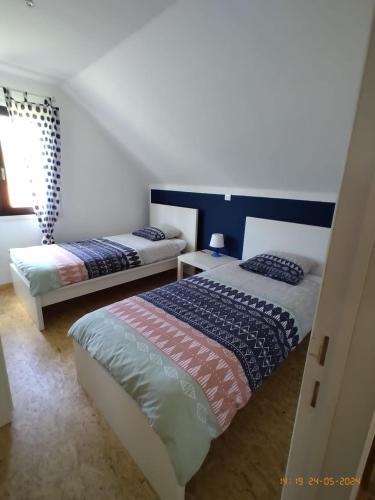 une chambre avec deux lits et une fenêtre dans l'établissement La petite Borie, à Payrignac