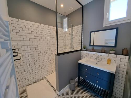 une salle de bain avec un lavabo bleu et un miroir dans l'établissement Les Gîtes de Monte Blanco Le Ramonetage, à Montblanc
