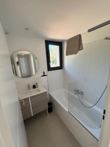 une salle de bain avec une baignoire, un lavabo et un miroir dans l'établissement VillaGassin 403, à Saint-Tropez