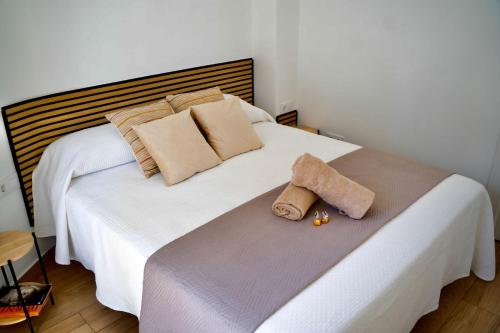 een wit bed met twee kussens en een handdoek erop bij Casa Albita Calpe in Calpe