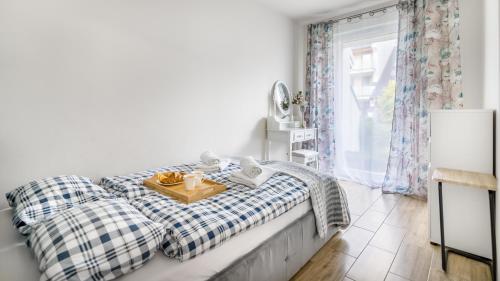 a bedroom with a bed with a tray of food on it at Apartamenty Piamola Jantar Park in Jantar
