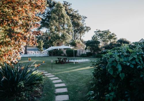 a garden with a table and a picnic table at The Village Lodge in Stormsrivier
