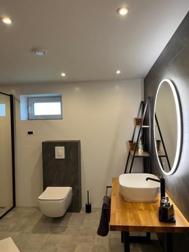 ein Badezimmer mit Toilette, Waschbecken und Spiegel in der Unterkunft Apartament Ratvika in Ålesund