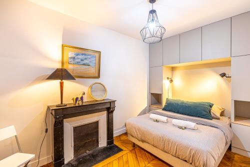 une chambre avec un lit et une cheminée dans l'établissement GuestReady - Apt Près Du Musée De Montmartre, à Paris