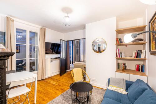 un salon avec un canapé bleu et une table dans l'établissement GuestReady - Apt Près Du Musée De Montmartre, à Paris