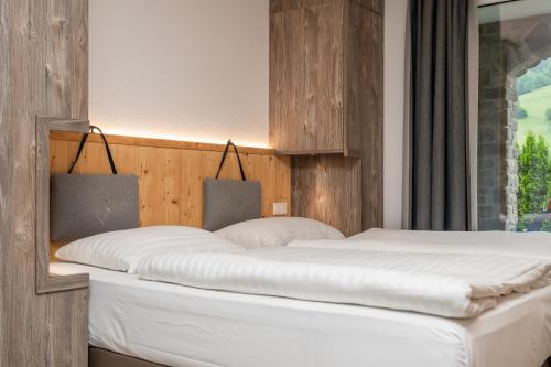 a bedroom with a large white bed in front of a window at AvenidA Panorama Suites in Kaprun