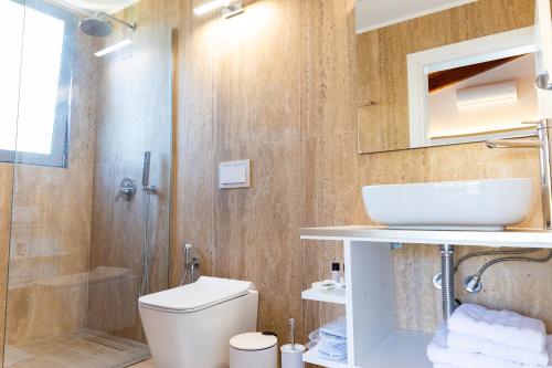 a bathroom with a toilet and a sink and a shower at De Sol in Himare