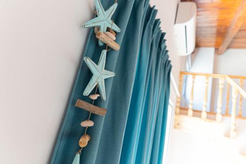 a row of blue surfboards with star decorations on a wall at De Sol in Himare