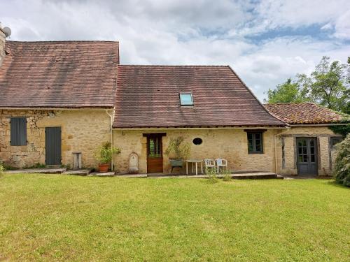 une ancienne maison en pierre avec une cour herbeuse dans l'établissement Maison à la campagne, à Lanquais