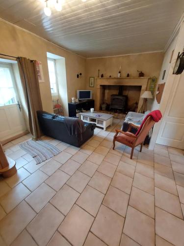 un salon avec un canapé et une cheminée dans l'établissement Maison à la campagne, à Lanquais
