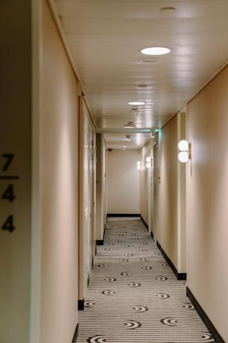 a long hallway with a tile floor in a building at Club Quarters Hotel St Paul's, London in London