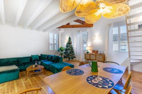 un salon avec un canapé vert et une table dans l'établissement GuestReady - Cosy and large duplex in Chartrons, à Bordeaux