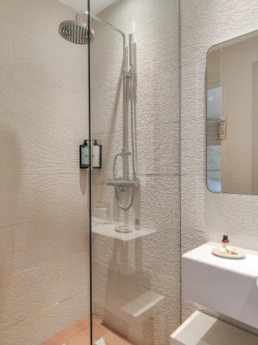 a bathroom with a shower and a sink at Hôtel Bor in Hyères