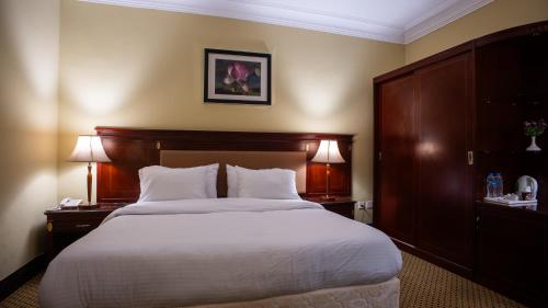 a bed in a hotel room with two lamps on tables at The Villa 604 Powered by look in Cairo