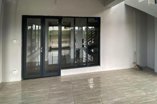 une pièce vide avec des portes vitrées dans un bâtiment dans l'établissement Apartment Riverdale by Dani room, à Tanahbaru