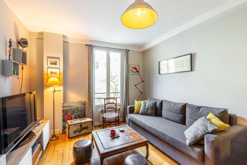 salon z kanapą i telewizorem w obiekcie GuestReady - Amazing stay in the 19th arr. w Paryżu
