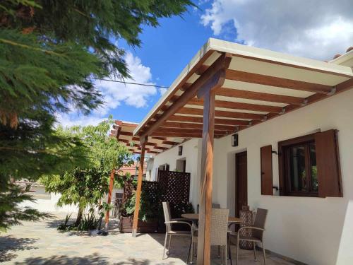 a patio with a wooden pergola on a house at Petrichor houses in Portariá