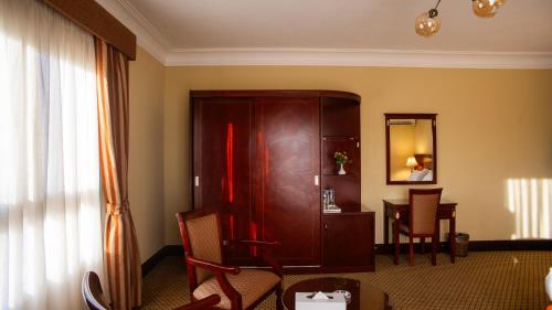 a living room with a large wooden cabinet and a table at The Villa 604 Powered by look in Cairo