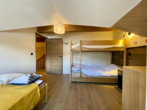 deux lits superposés dans une chambre avec parquet dans l'établissement Homency - Résidence Fermes de l'Alpe D302, à L'Alpe-d'Huez