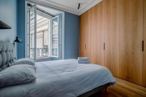 une chambre avec un grand lit avec une fenêtre dans l'établissement GoodGuest- Luxe Stade Tour Eiffel 2BDR, à Paris