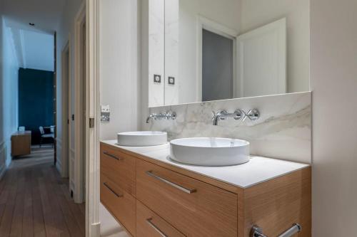 une salle de bain avec deux lavabos et un grand miroir dans l'établissement GoodGuest- Luxe Stade Tour Eiffel 2BDR, à Paris