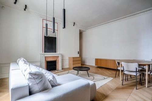 un salon avec un canapé blanc et une table dans l'établissement GoodGuest- Luxe Stade Tour Eiffel 2BDR, à Paris