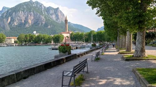 eine Reihe von Bänken neben einem Gewässer in der Unterkunft La Movida in Lecco