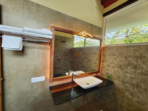 a bathroom with a sink and a mirror at Malgudi Farms in Bangalore