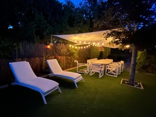 a table and chairs in a backyard at night at La Amapola in Valdemorillo