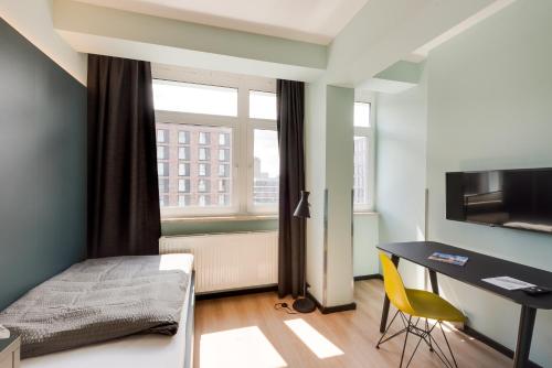 a bedroom with a bed and a desk and a window at MIAMI House in Hamburg