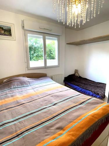 une chambre avec un grand lit et un lustre dans l'établissement Jolie Appartement de Bord de la Mer Côte d'Azur, à Roquebrune-Cap-Martin