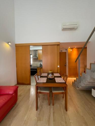 a living room with a table and a red couch at Born To Stay In Milfontes in Vila Nova de Milfontes