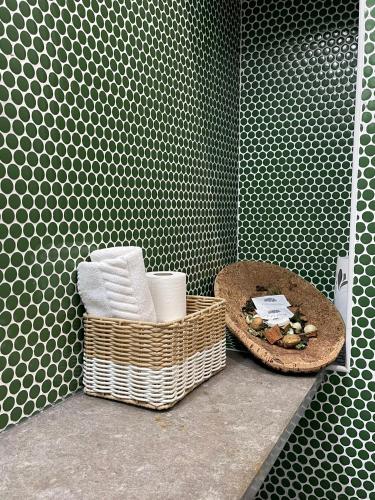 a bathroom with a basket of towels and a sink at Born To Stay In Milfontes in Vila Nova de Milfontes