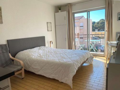 une chambre avec un lit et une vue sur un balcon dans l'établissement Studio rénové climatisé avec balcon, parking et wifi à Balaruc-les-Bains - FR-1-553-66, à Balaruc-les-Bains