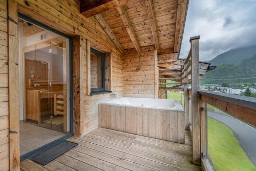 a wooden house with a bath tub on a deck at AvenidA Panorama Suites in Kaprun