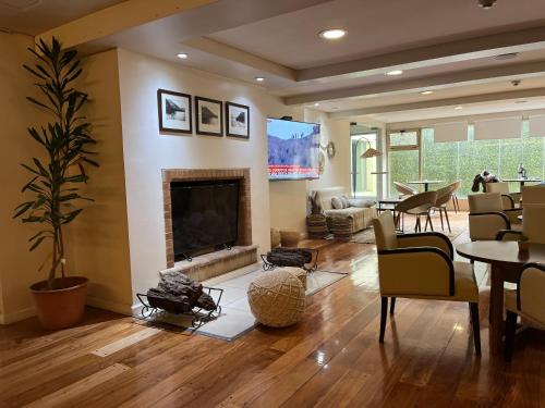 a living room with a fireplace and a dining room at Kenton Palace Bariloche in San Carlos de Bariloche