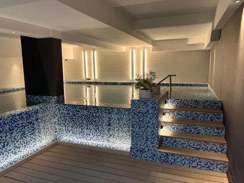 a bathroom with a blue tile floor and stairs at Kenton Palace Bariloche in San Carlos de Bariloche