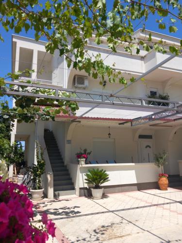 a white house with stairs and potted plants at Vila Nina Donji Štoj in Ulcinj