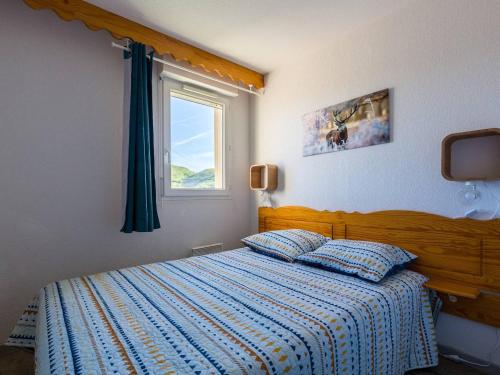 a bedroom with a bed with a blue comforter and a window at Appartement Rénové Peyragudes - 8 Pers, Balcon, 2 Chambres + Cabine, Parking Gratuit, Proche Pistes - FR-1-695-10 in Germ