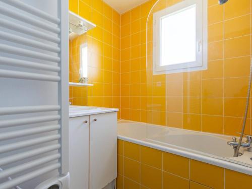 a yellow bathroom with a tub and a sink at Appartement Rénové Peyragudes - 8 Pers, Balcon, 2 Chambres + Cabine, Parking Gratuit, Proche Pistes - FR-1-695-10 in Germ