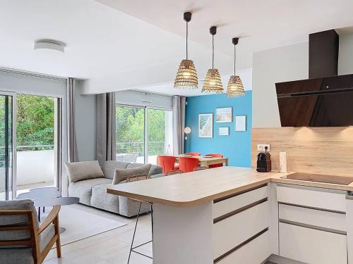 une cuisine et un salon avec un canapé et une table dans l'établissement Appartement Standing avec Terrasse, Piscine et Accès Plage, 2 Chambres, Climatisé, Parking, PMR - FR-1-770-28, à Saint-Cyr-sur-Mer