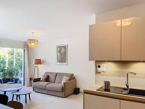 une cuisine et un salon avec un canapé et une table dans l'établissement Appartement à 150m plage des Lecques, climatisé, piscine, terrasse, 2 chambres, parking - 4 étoiles - FR-1-770-29, à Saint-Cyr-sur-Mer