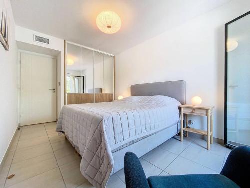 une chambre avec un grand lit et un miroir dans l'établissement Appartement à 150m plage des Lecques, climatisé, piscine, terrasse, 2 chambres, parking - 4 étoiles - FR-1-770-29, à Saint-Cyr-sur-Mer