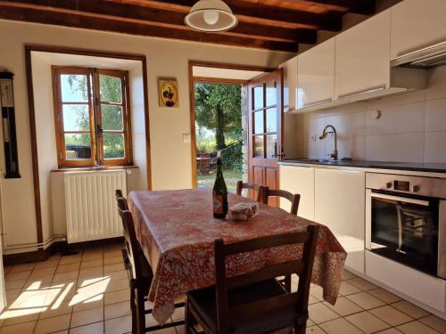 - une cuisine avec une table et une bouteille de vin dans l'établissement La Maison du Boscq, à Cametours