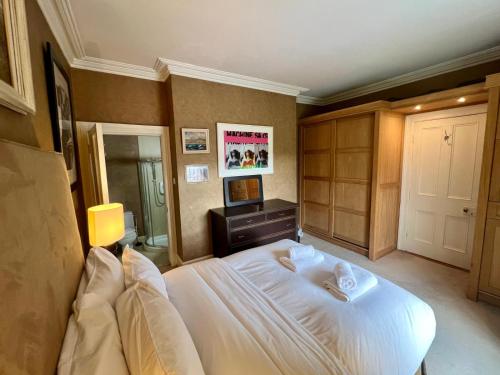 a bedroom with a large white bed and a mirror at Burlington Townhouse in Dublin
