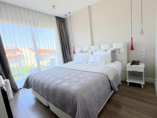 a bedroom with a large bed and a large window at Ferush Boutique Hotel in Urla