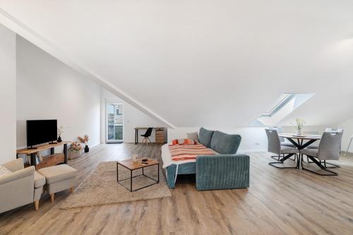 a white living room with a couch and a table at Neubau Ferienwohnung Kleine Auszeit in Sinzheim