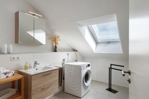 a bathroom with a washing machine and a sink at Neubau Ferienwohnung Kleine Auszeit in Sinzheim