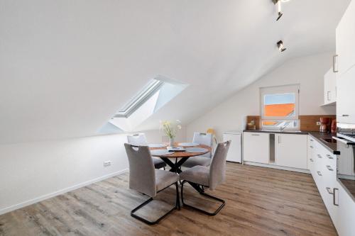 a kitchen and dining room with a table and chairs at Neubau Ferienwohnung Kleine Auszeit in Sinzheim